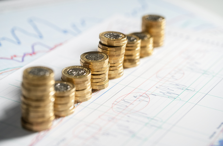 8 piles of varying sizes of sterling one pound coins sitting on a graph.