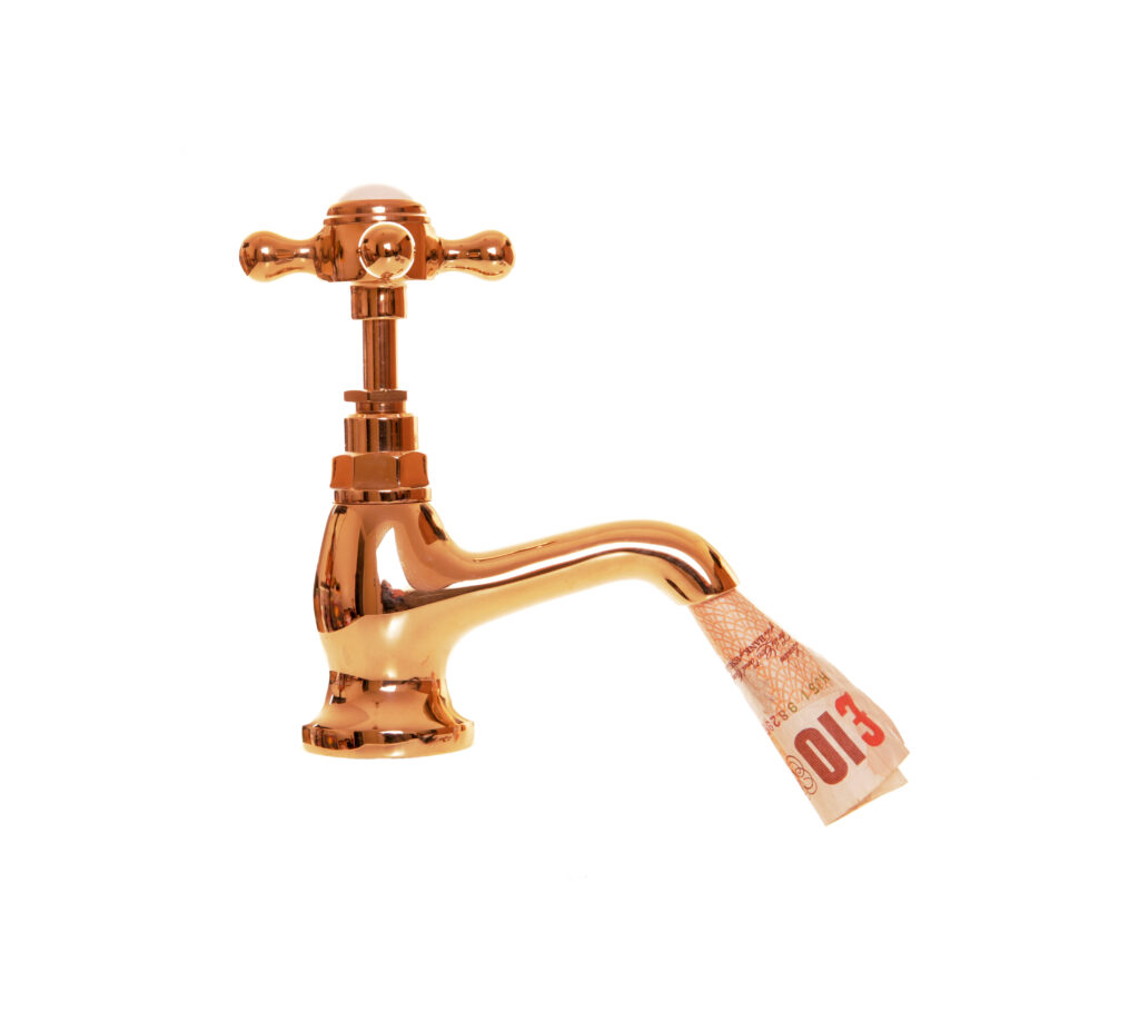 White background with a gold victorian style tap. A rolled up sterling ten pound note is pouring from the tap.