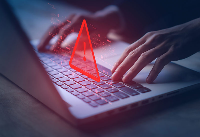 Laptop keyboard with warning triangle.